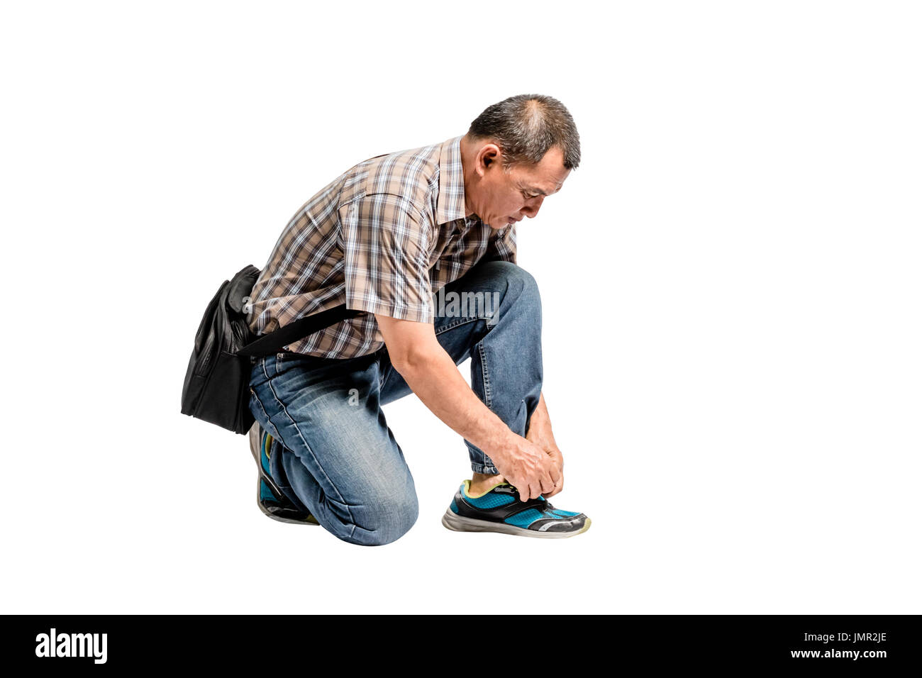 Portrait of a happy mature man in scott shirt and blue jeans tying his  shoes. Isolated full length on white background with copy space and  clipping pa Stock Photo - Alamy