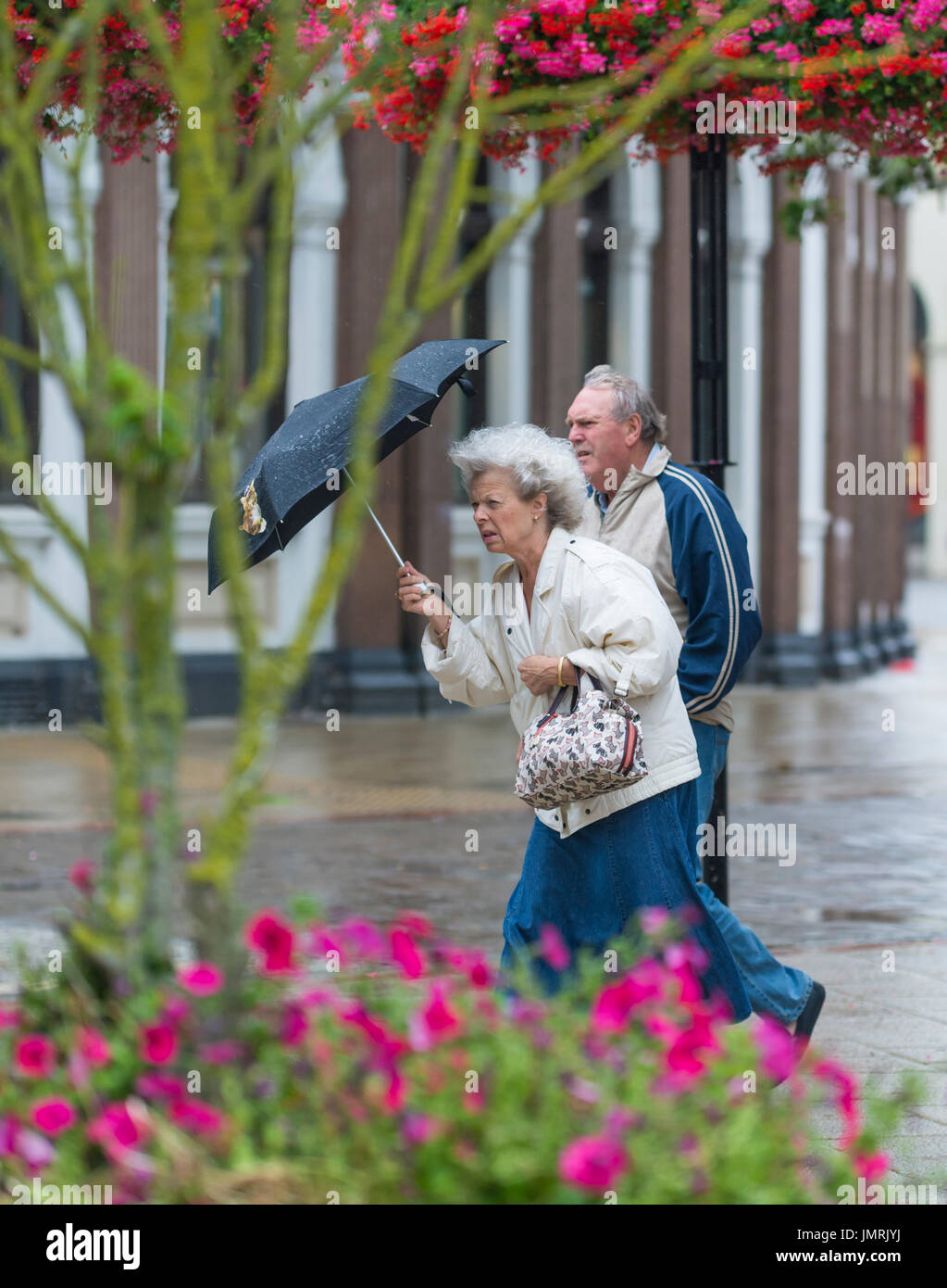 Lady walking in rain with umbrella hires stock photography and images