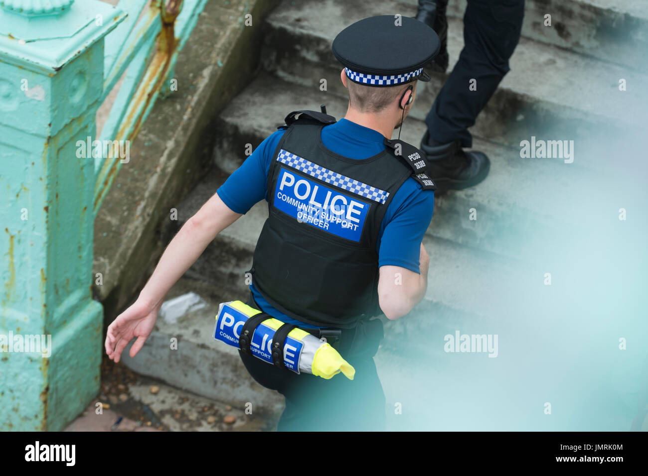PCSO (Police Community Support Officer) running up steps in Brighton, East Sussex, England, UK. Stock Photo