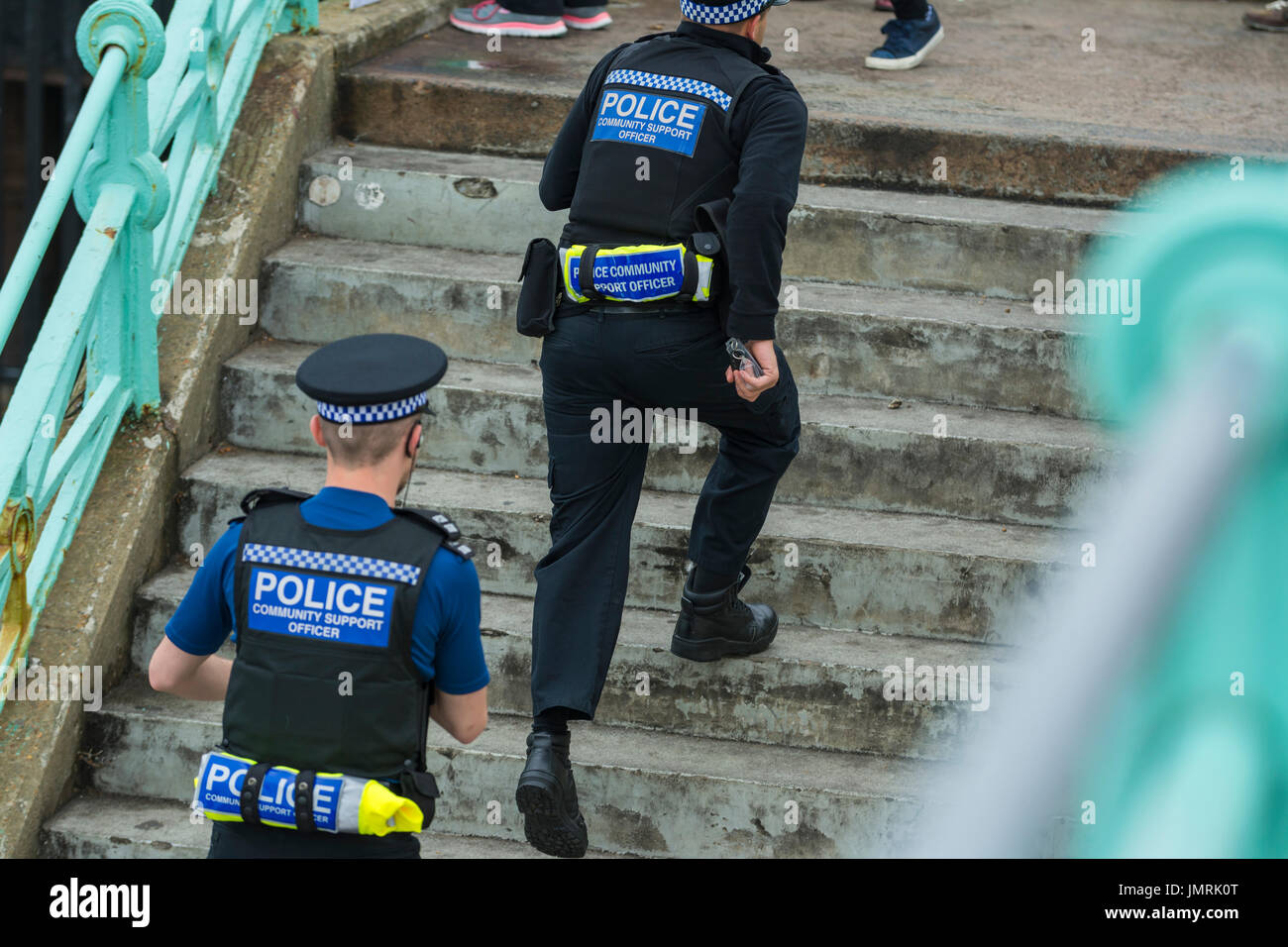 PCSOs (Police Community Support Officers) running up steps in Brighton, East Sussex, England, UK. Stock Photo