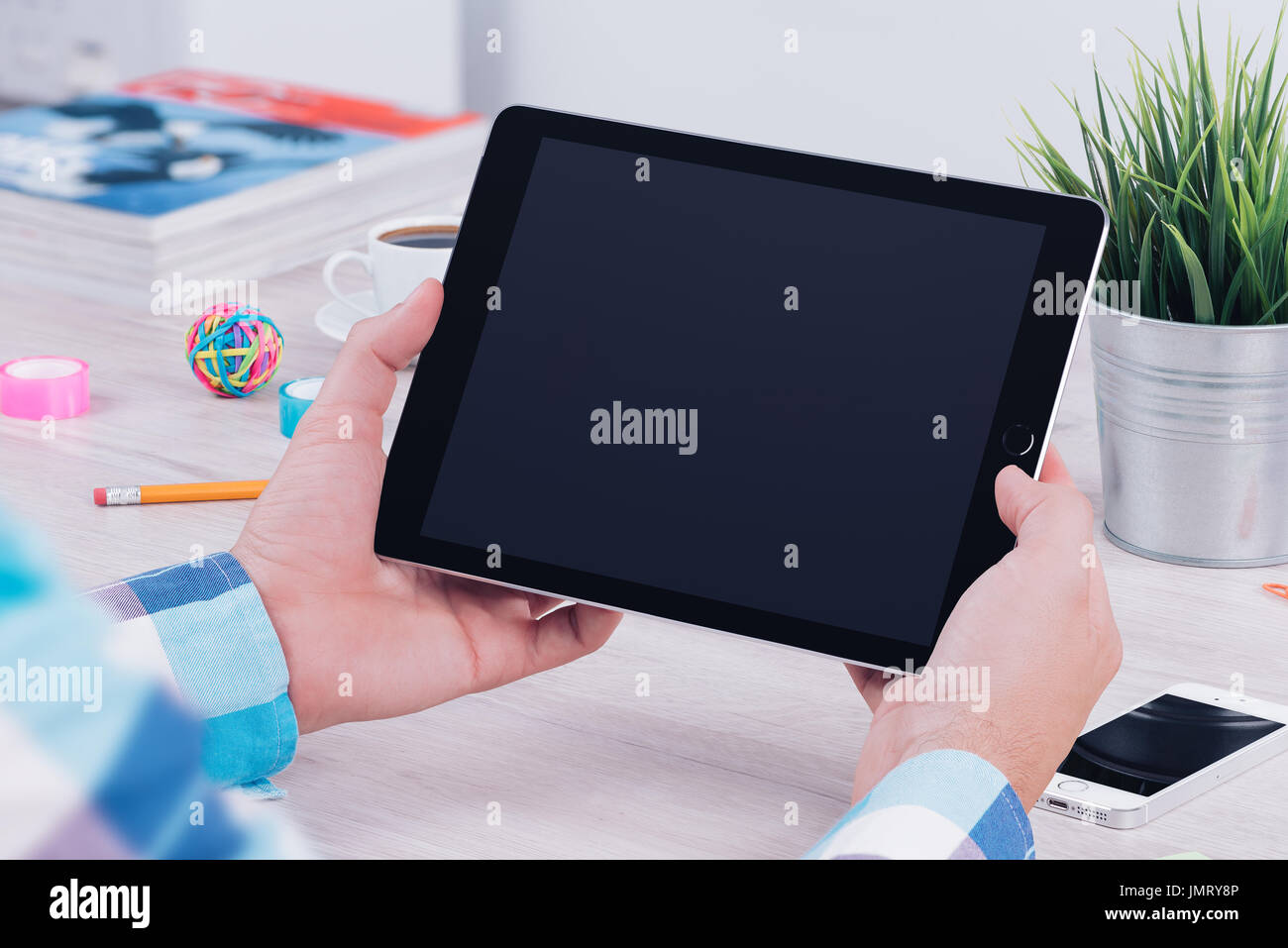 Young man using tablet computer at the office workplace. Stock Photo