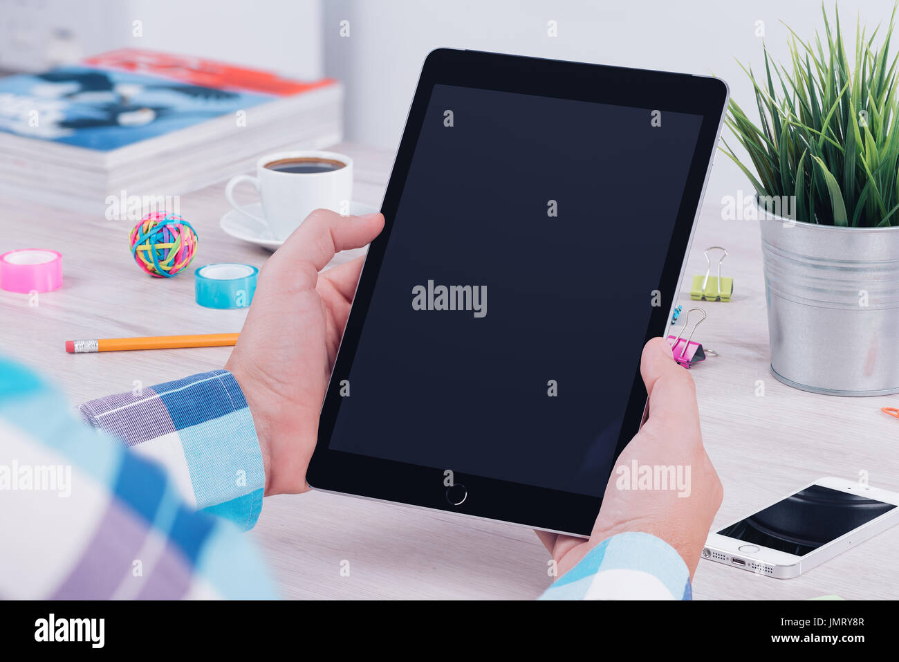Young man using tablet computer at the office workplace. Stock Photo