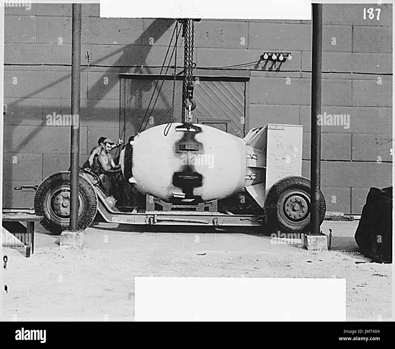 FM (Fat Man) atomic bomb unit being placed on trailer cradle in front of Assembly Building 2