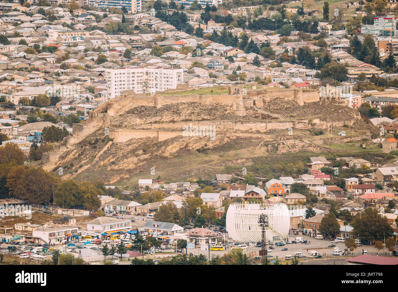 Gori, Shida Kartli Region, Georgia. Cityscape With Medieval Citadel Fortress Goris Tsikhe, Modern Building Of Justice House And Bus Station In City Ce Stock Photo