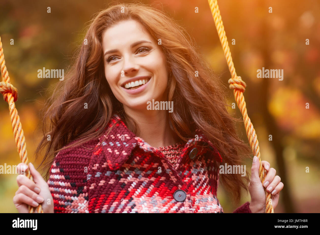 Woman on a swing in an autumn park Stock Photo