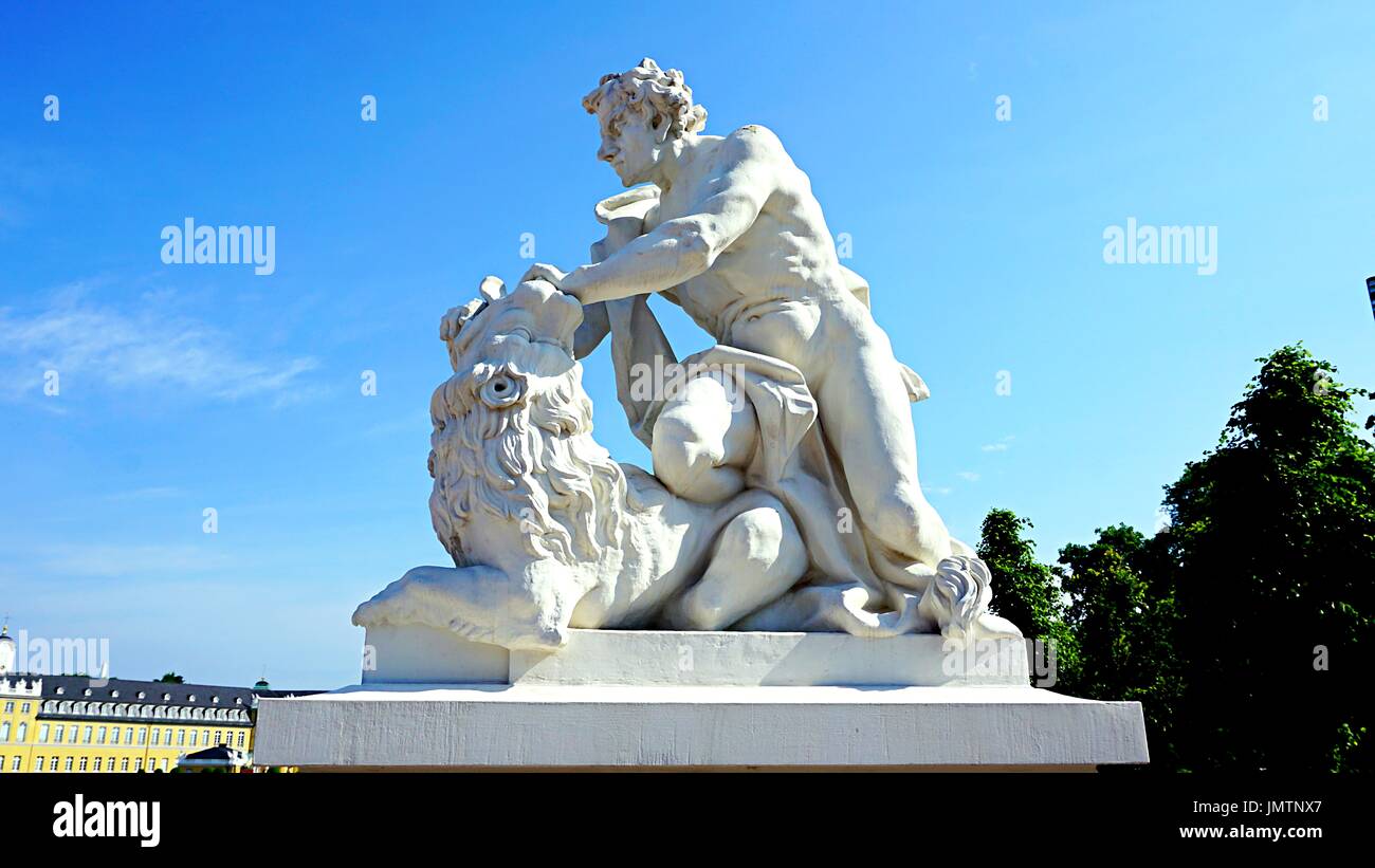 Statues of Greek god fighting with lion in front of Karlsruhe Palace or Schloss Karlsruhe in Karlsruhe, Germany. Stock Photo