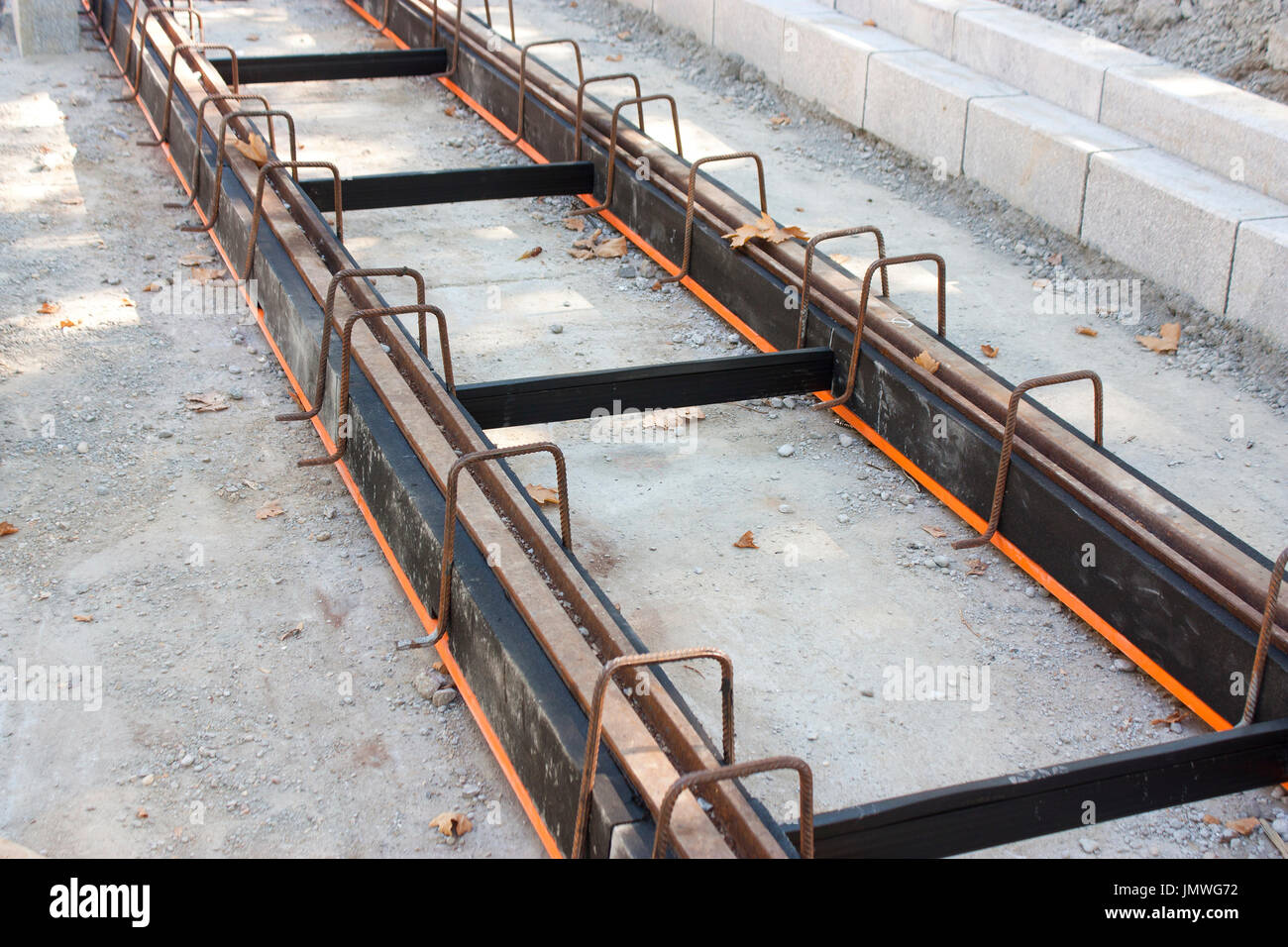Construction of tramway track with steel rails coating - vibration damping material for noise reduction, in the urban area Stock Photo