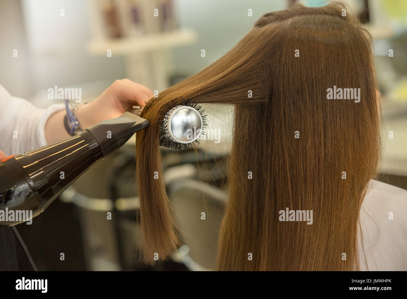 Young female sitting in hair salon hairdo styling hair dry Stock Photo