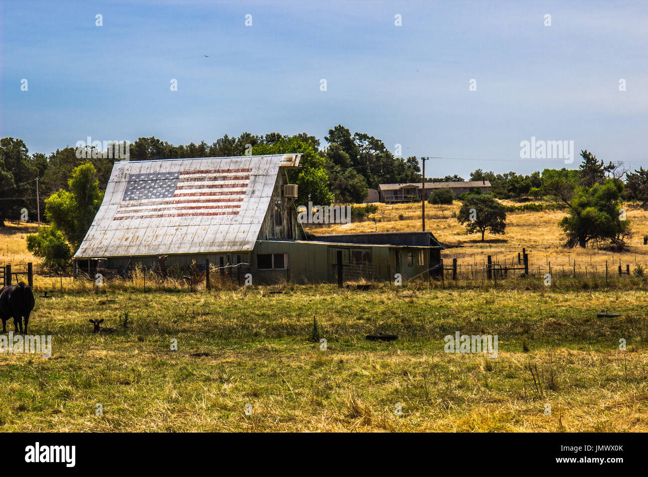 Old Wooden Barn With American Flag On Tin Roof Stock Photo