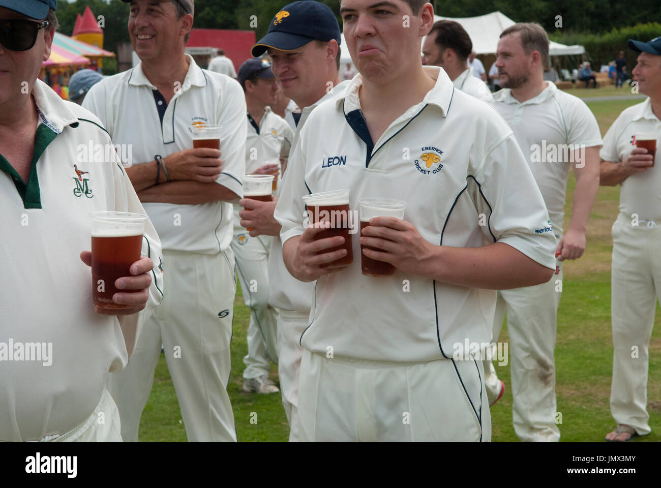 English village life cricket team with pints of beer during the lunch break in play.  Ebernoe cricket club play an annual Horn Fair cricket match on the Common.  Ebernoe CC versus Wessex Pilgrims Cricket Club. Ebernoe, Sussex, England. 2010s 2015 UK HOMER SYKES Stock Photo