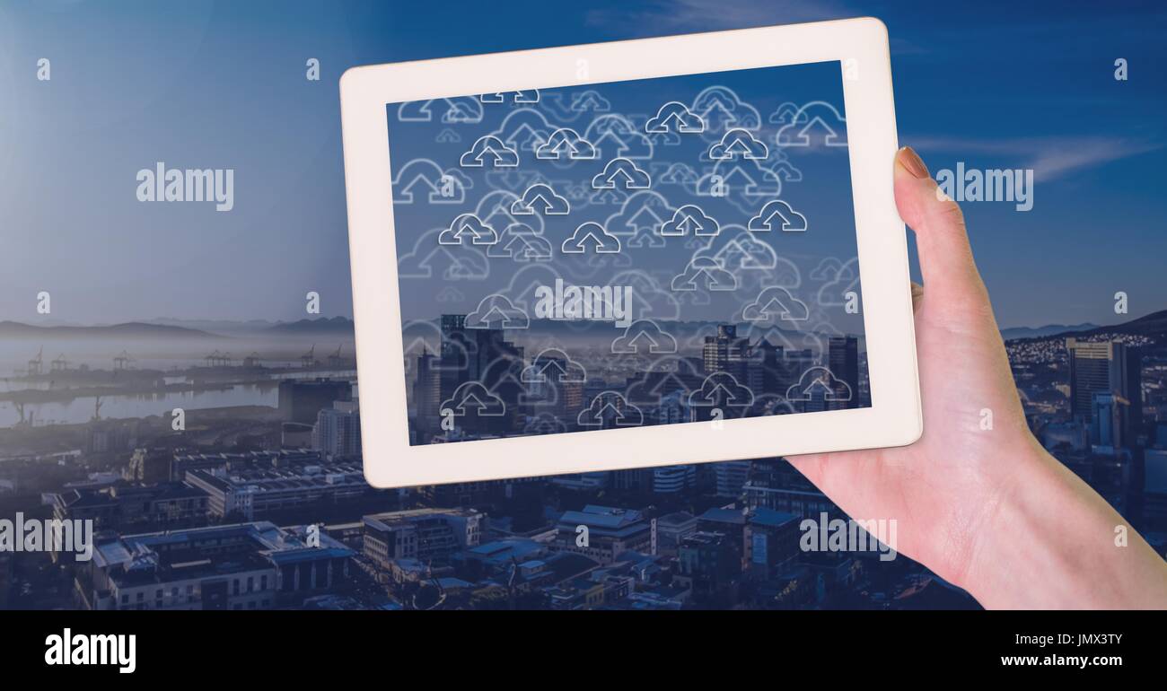 Digital composite of Holding tablet and City with cloud upload icons ...
