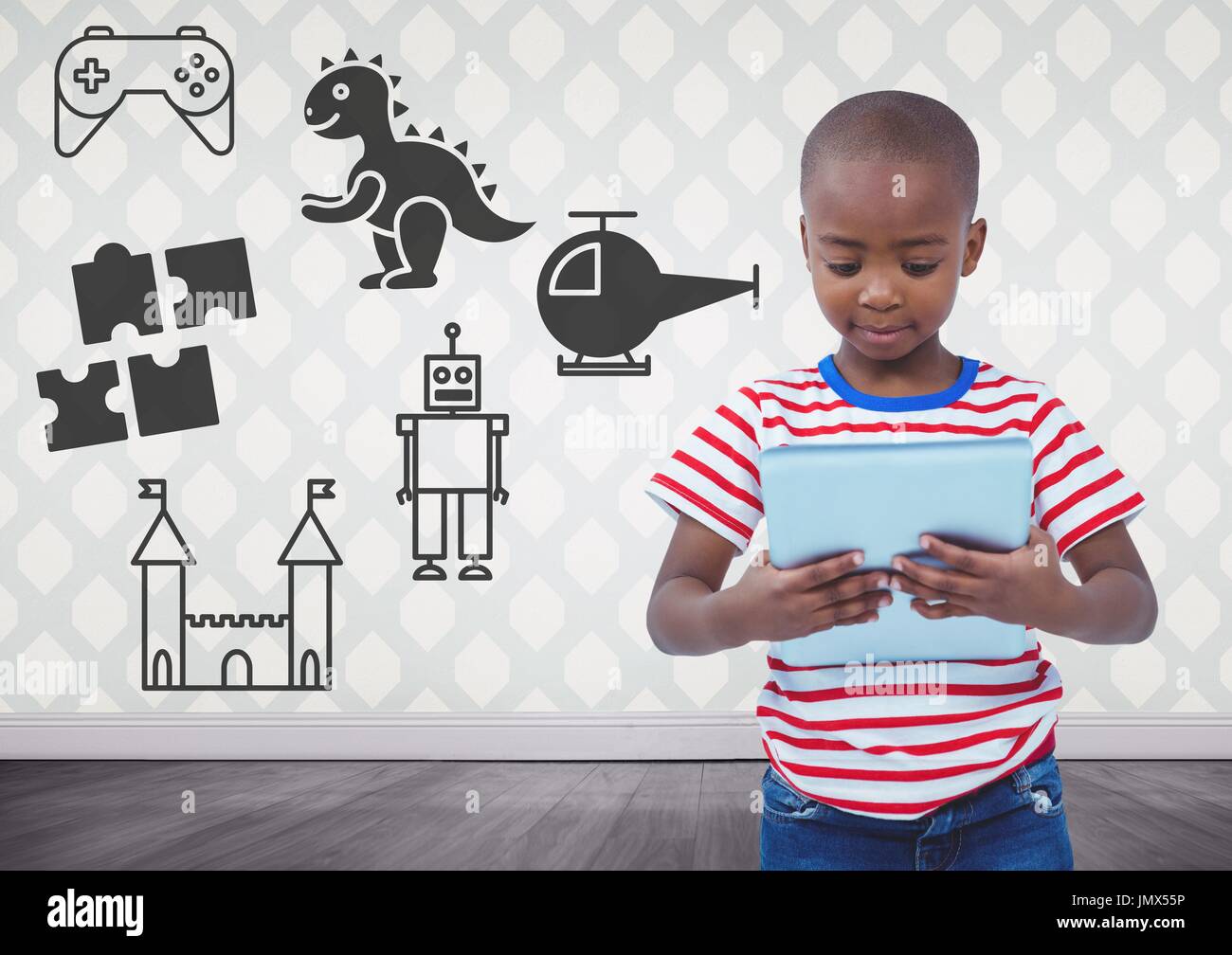 Digital composite of Boy holding tablet in blank room with toys graphics Stock Photo