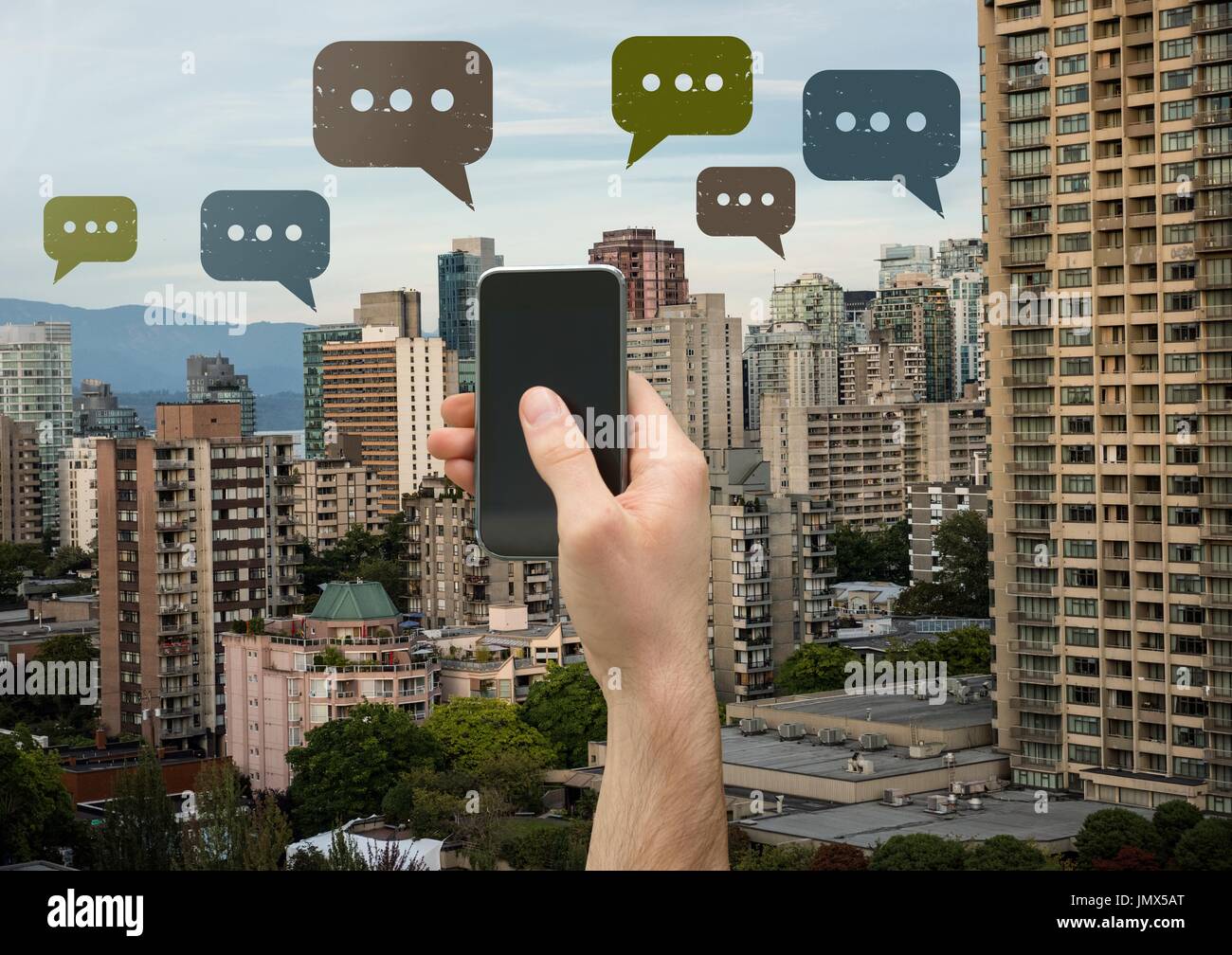 Digital composite of Holding phone and Chat bubble icons over city Stock Photo