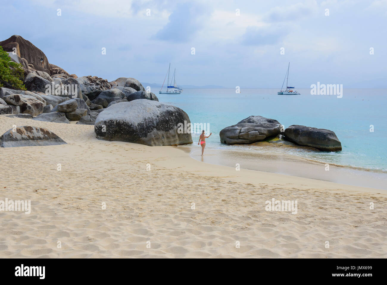 Spring bay with boulder and walking people, Virgin Gorda Island, British Virgin Islands, Caribbean Sea Stock Photo