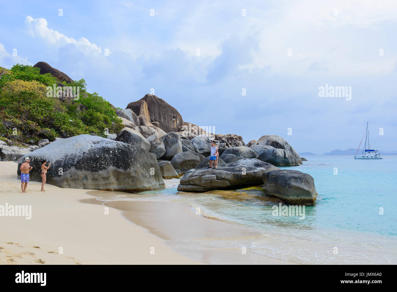 Spring bay with boulder and walking people, Virgin Gorda Island, British Virgin Islands, Caribbean Sea Stock Photo