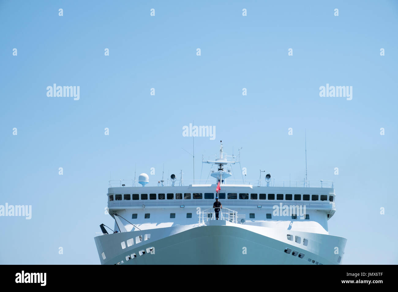 Sailor on the prow of ship as it pulls in to harbour. Greece Stock Photo
