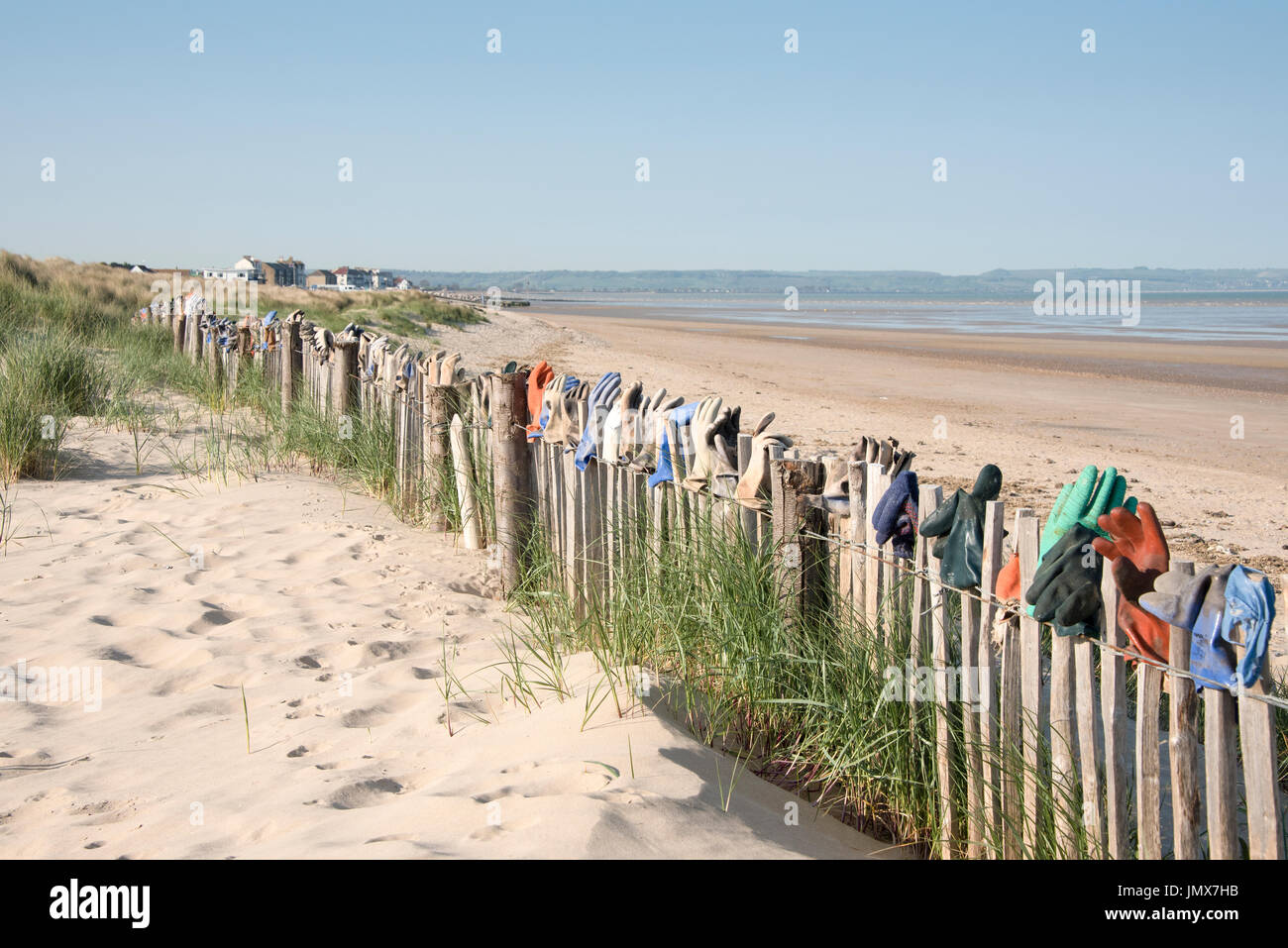 Fence by the sea covered with lost gloves in the town of Greatness,Kent,UK. Stock Photo