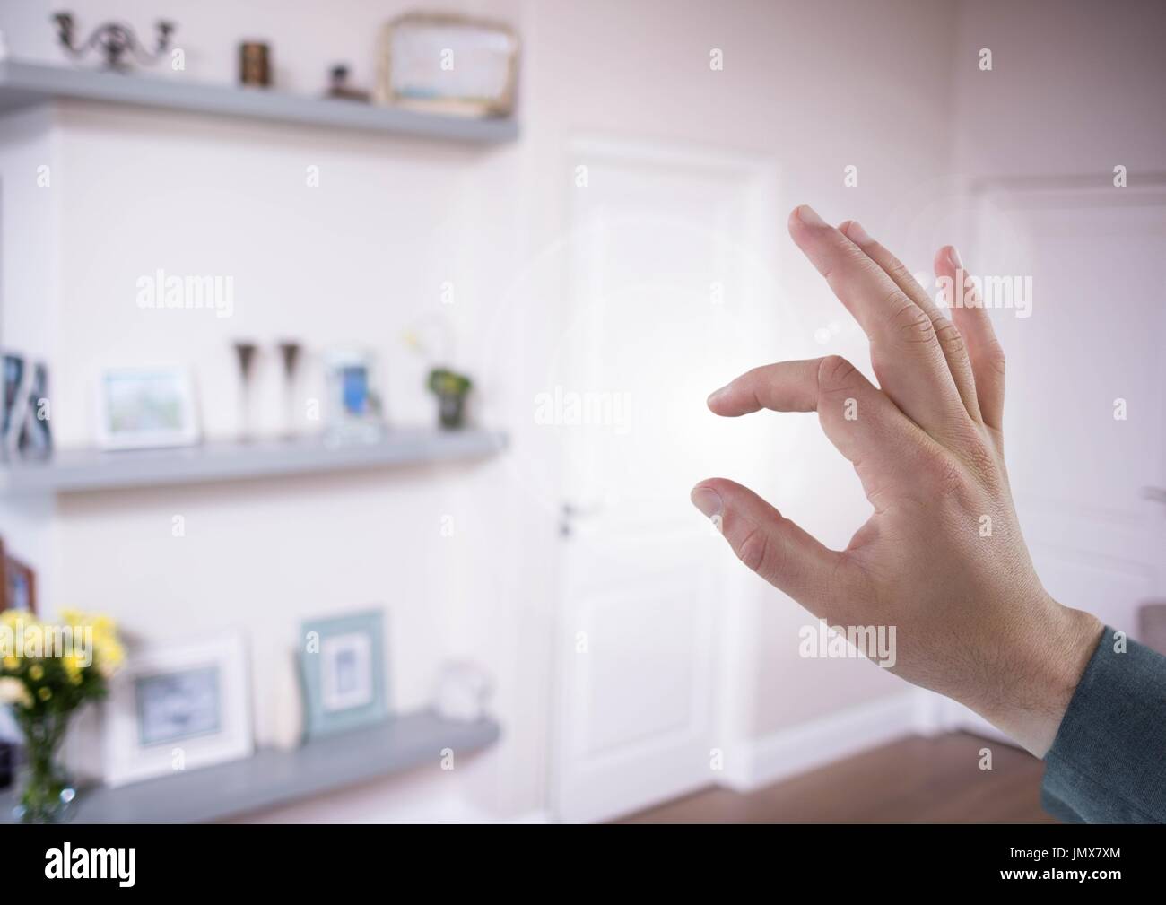 Digital composite of Hand touching air of living room Stock Photo - Alamy