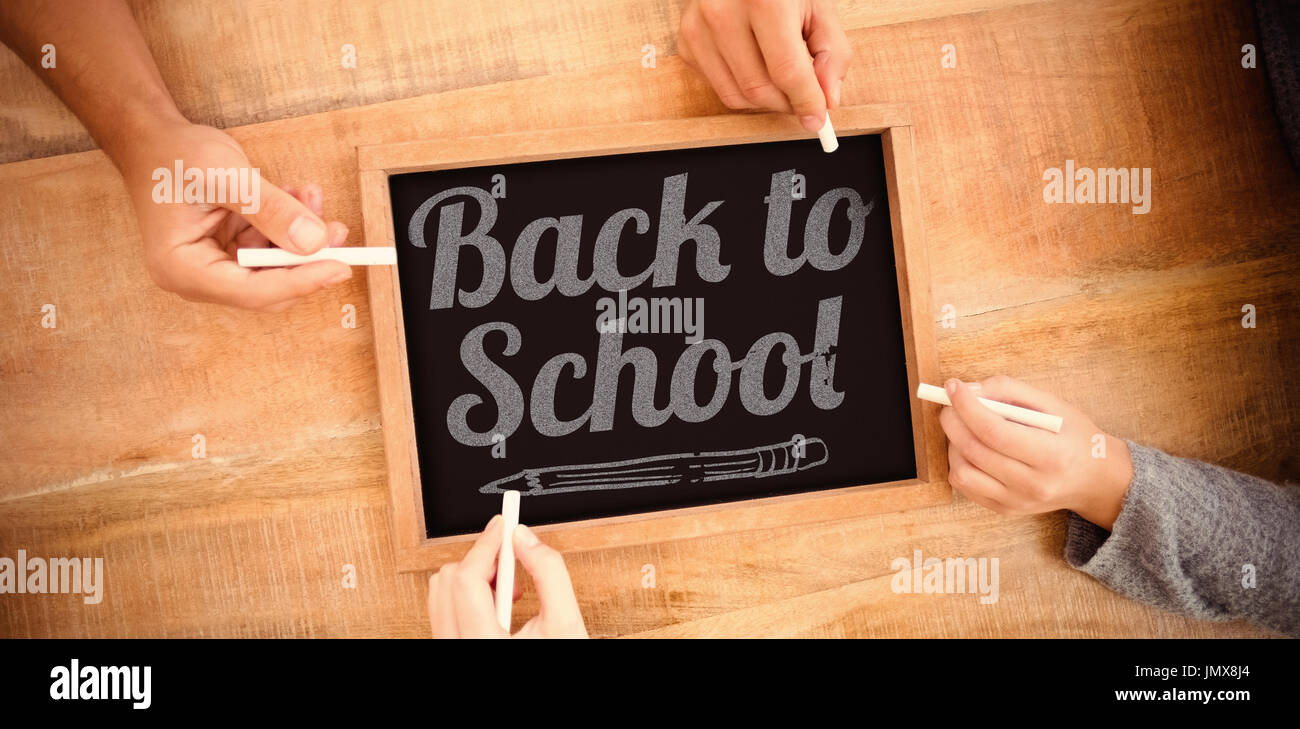 Back to school text over white background against hands writing on chalkboard Stock Photo