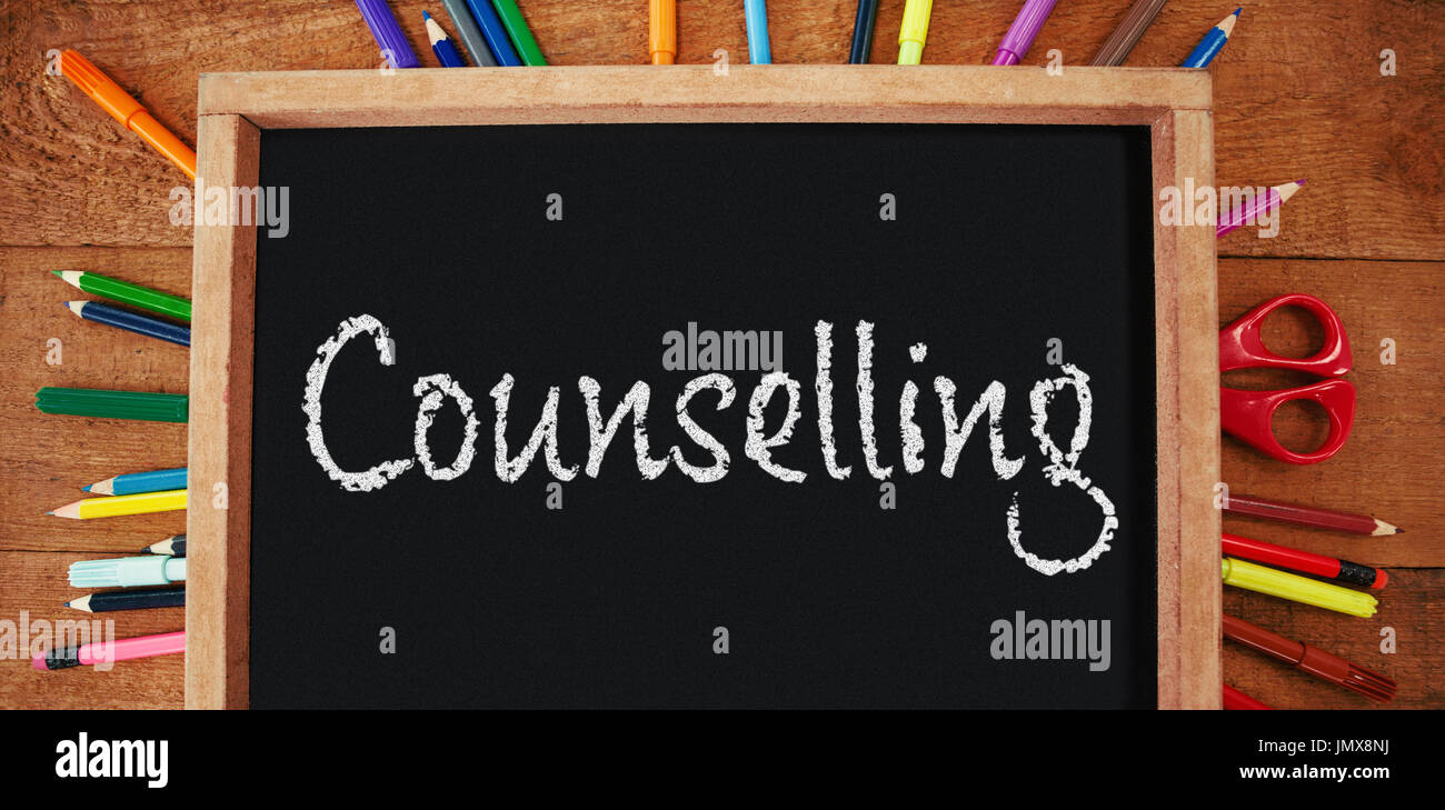 Counselling text against white background against high angle view of empty chalkboard with colorful equipment Stock Photo