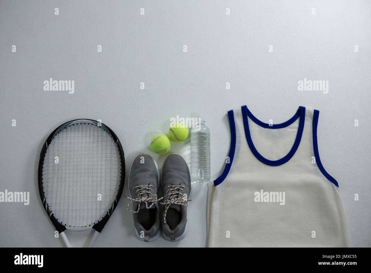 Racket with ball and sports shoe by vest on white background Stock ...
