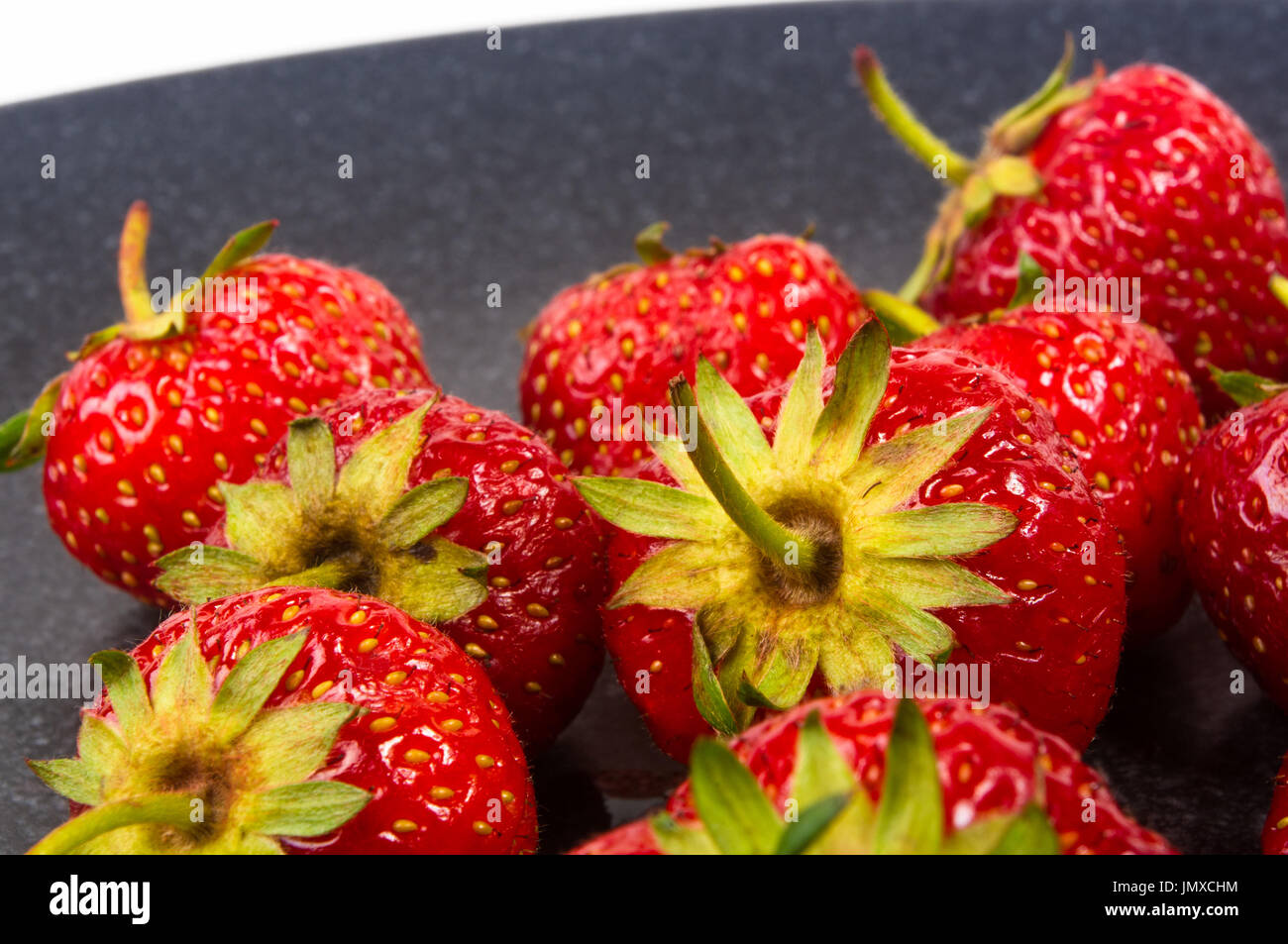 fresh ripe berries strawberries on black ceramic plate on white ...