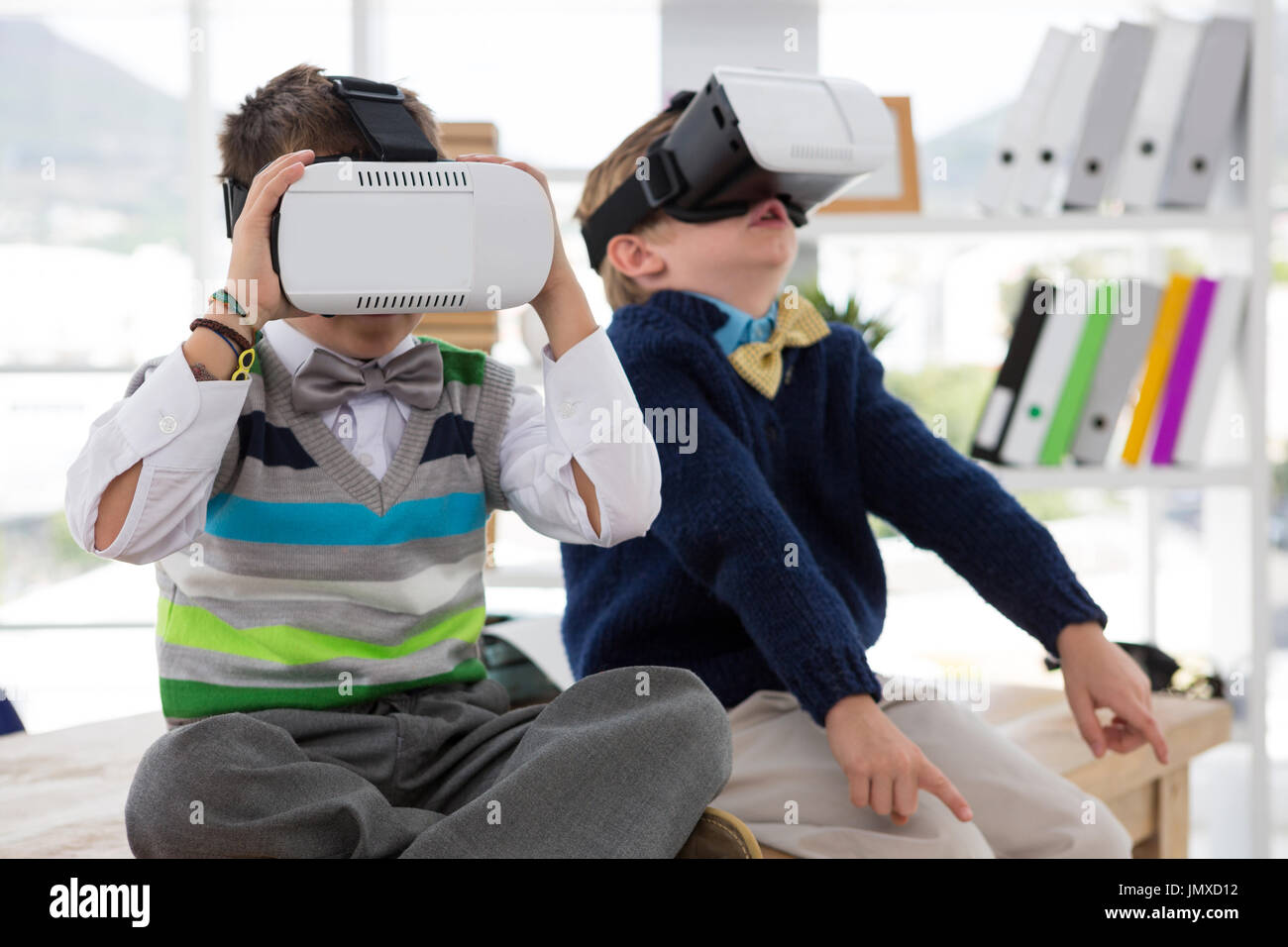 Kids as business executives using virtual reality headset in office Stock Photo