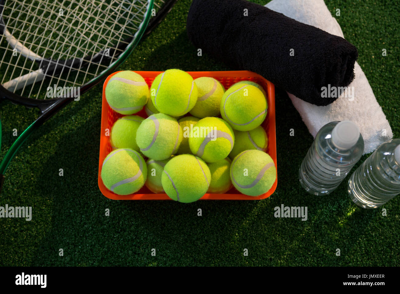 Overhead view of tennis balls in container amidst rackets and napkins