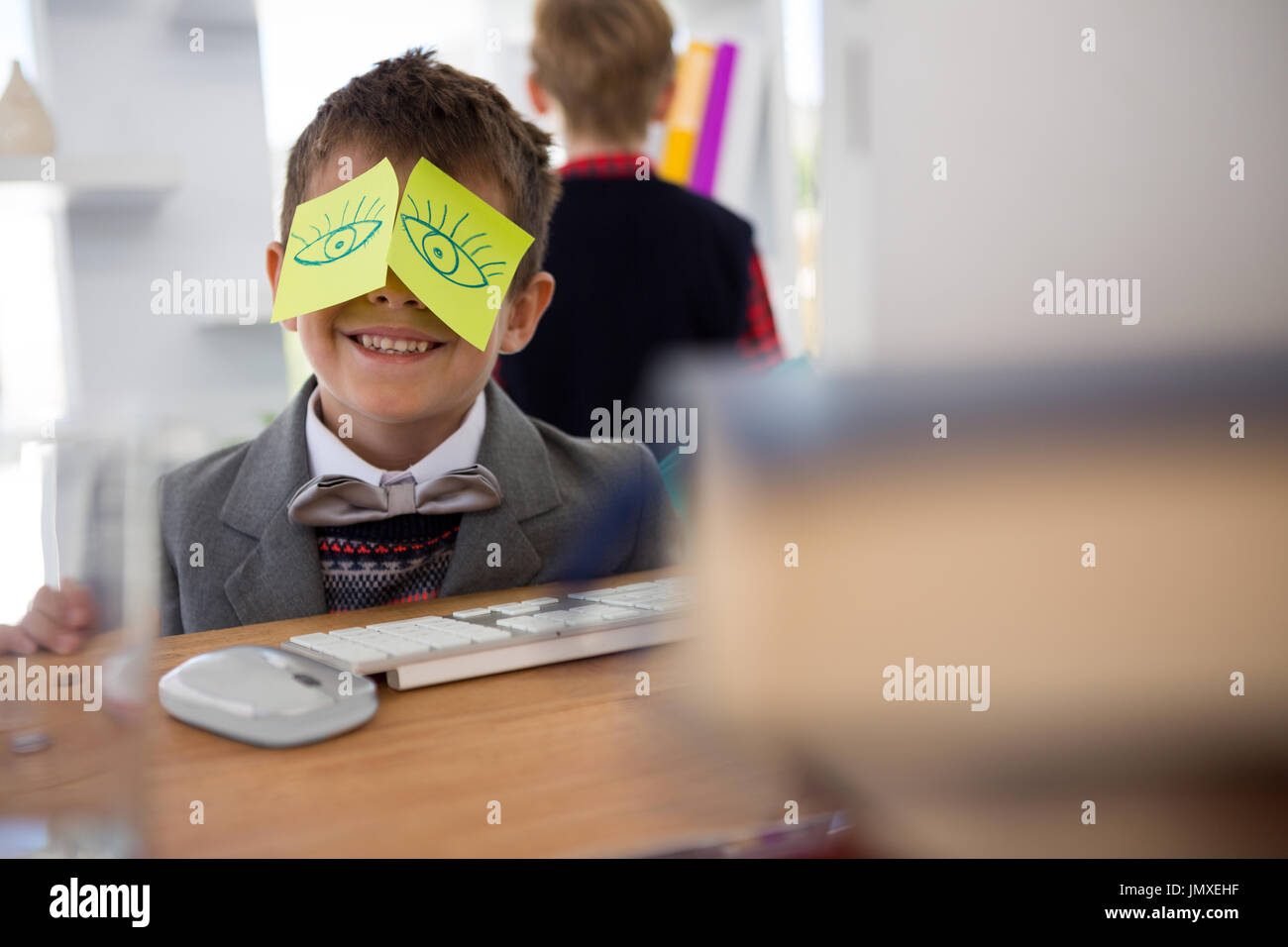 Boy as business executive with sticky notes on his face in office Stock Photo