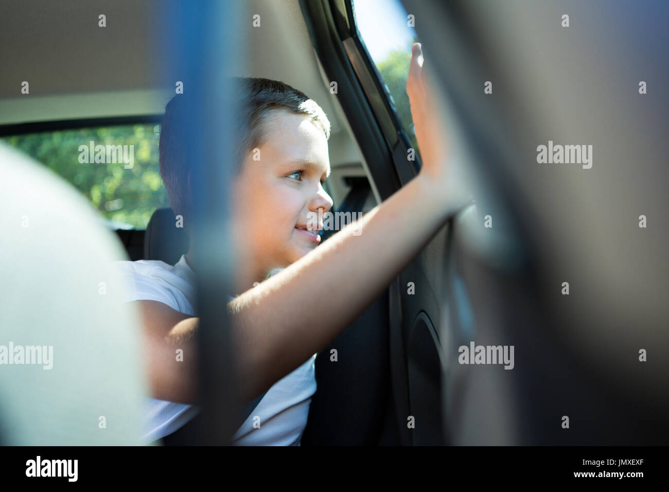 Happy teenage boy sitting in the back seat of car Stock Photo - Alamy