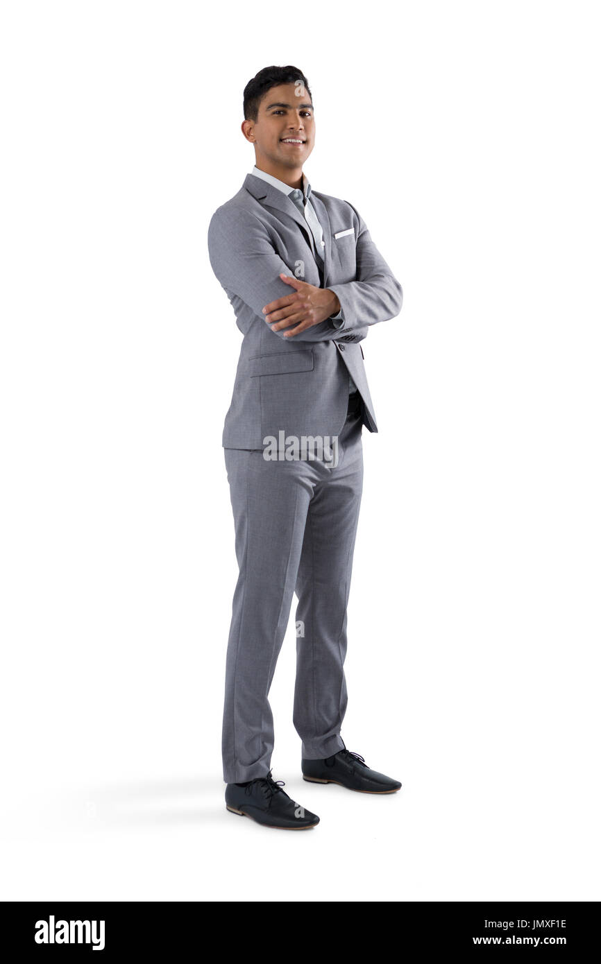 Portrait of businessman standing with arms crossed on white background ...