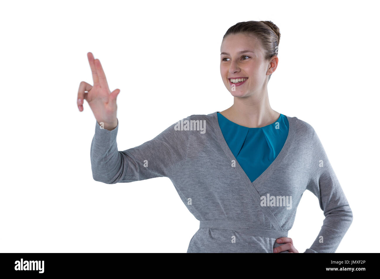 Smiling teenage girl pressing an invisible virtual screen against white ...