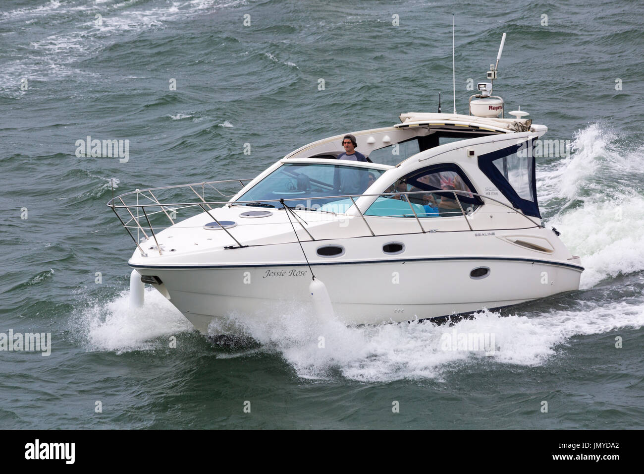 People in Sealine motor boat Jessie Rose in the Solent between Lymington and Yarmouth, Isle of Wight, Hampshire, UK in July Stock Photo