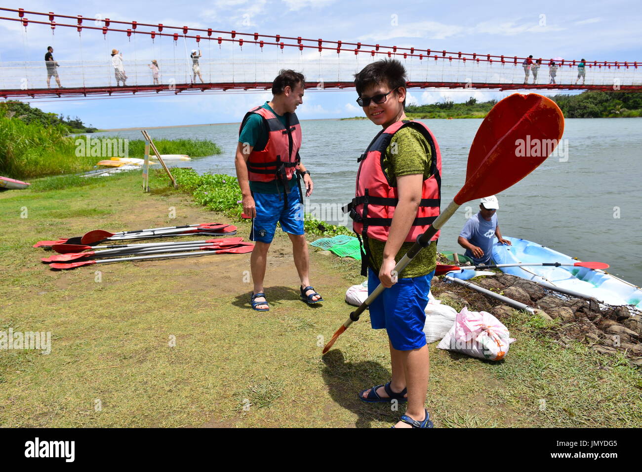 My husband and son canoeing on a lake outlet near coming from the ocean in Kenting, Taiwan. So fun, but a hot summer day. Stock Photo