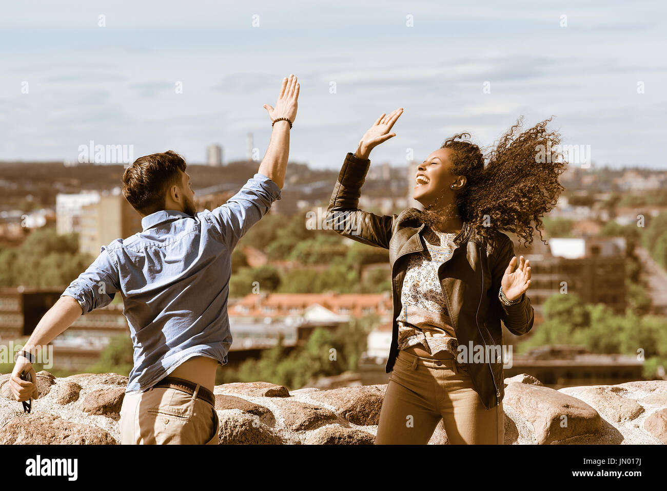 Young Smiling Multiracial Couple Having Fun While Clapping Their Hands ...