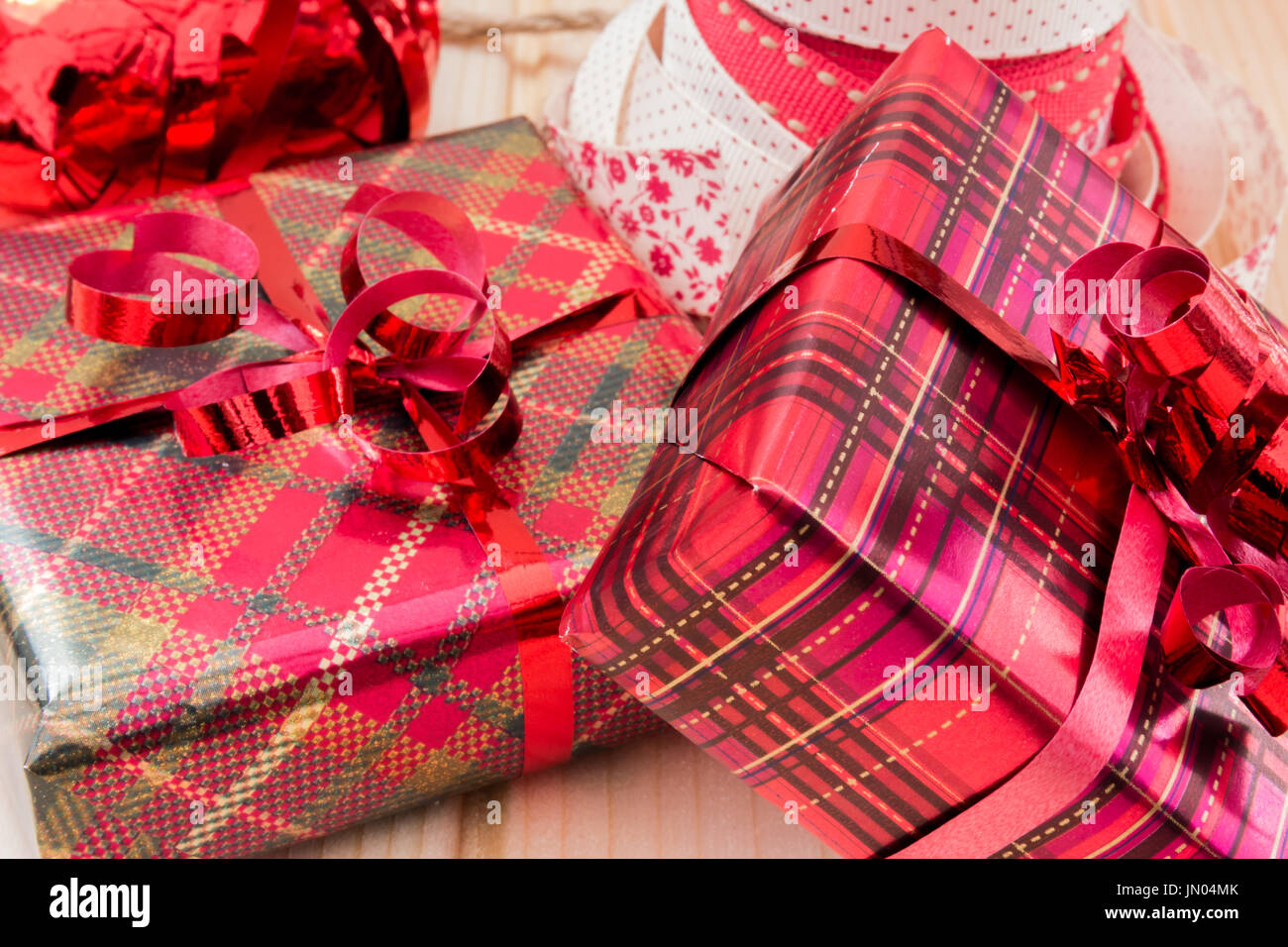 Two Christmas gifts wrapped up in Red and Gold glossy gift paper ...