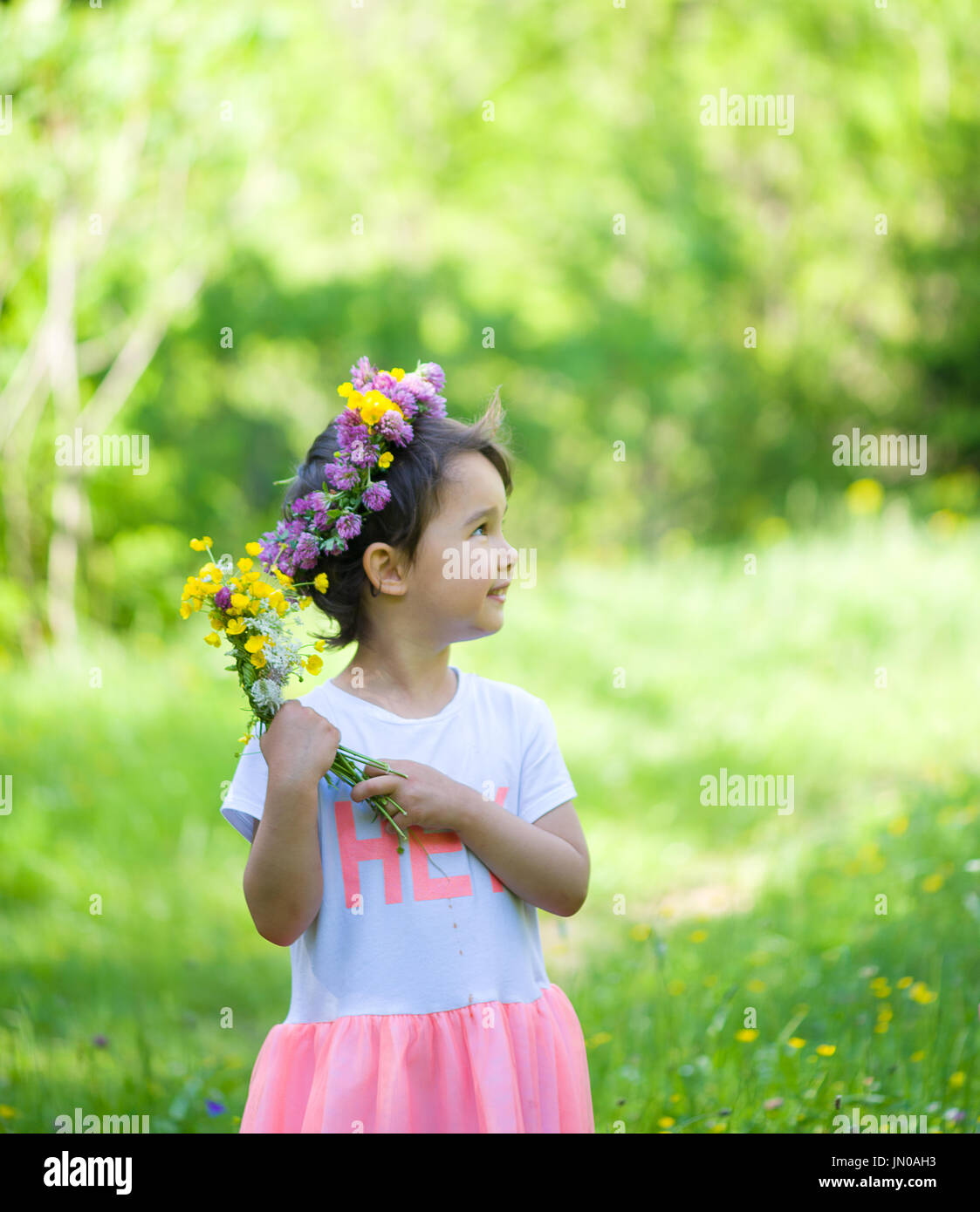 Portrait of a cheerful girl with a wreath of flowers on her head Stock Photo