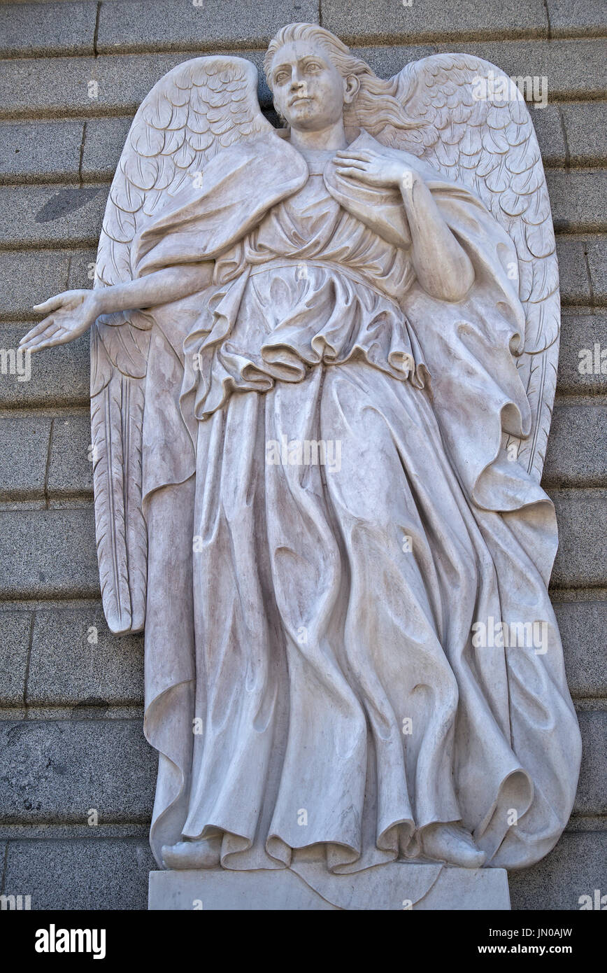 Statue of San Azrael angel, next to La Almudena Cathedral entry, in Madrid, Spain. The statue invites the watcher to enter the Cathedral. Stock Photo