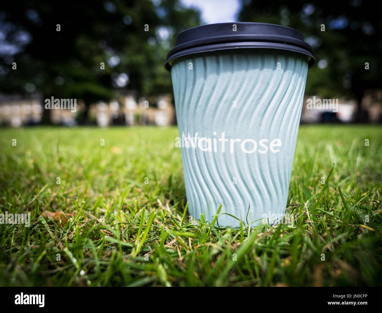 A Waitrose Complimentary Coffee Cup on a park lawn. Stock Photo