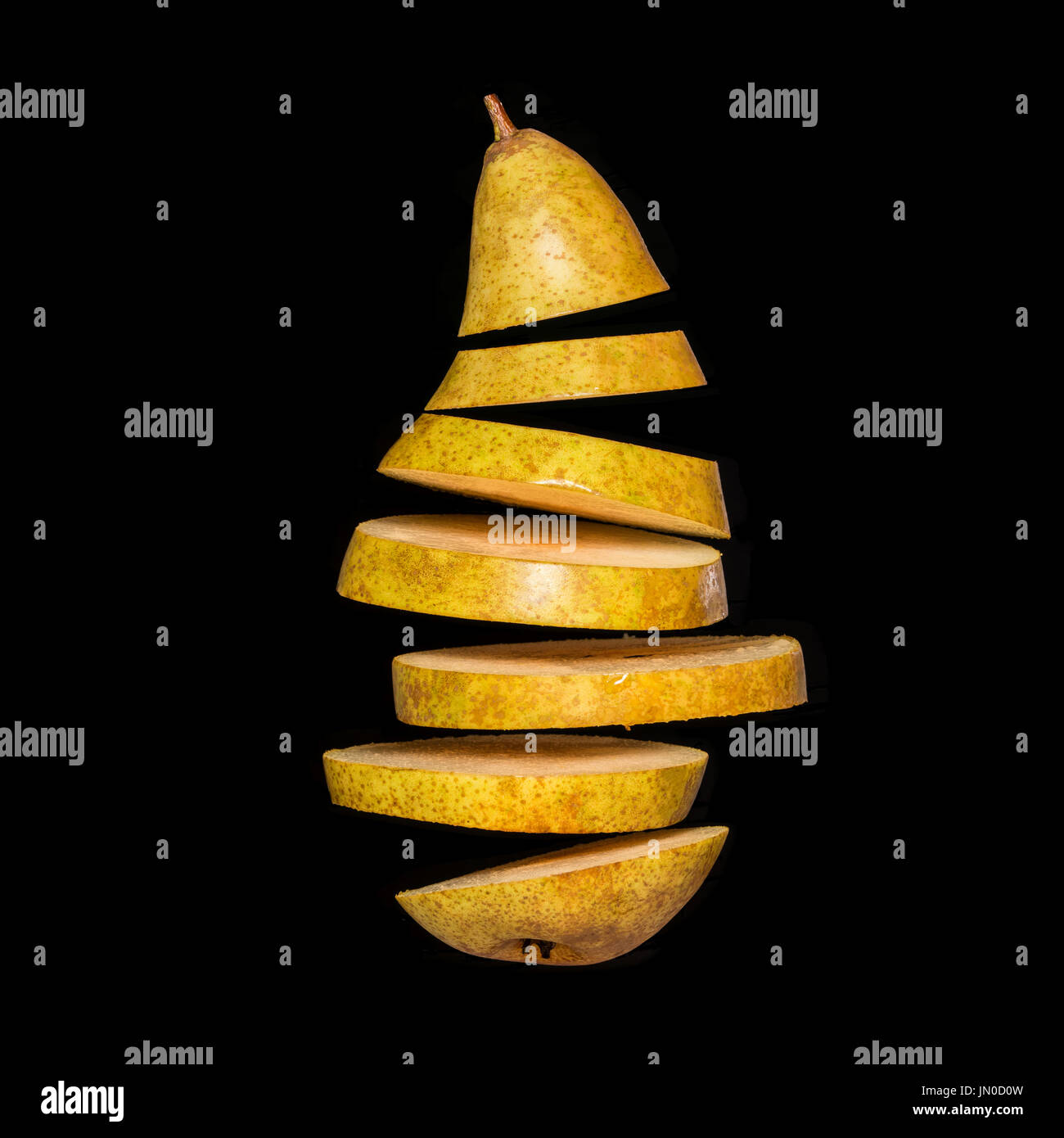 Creative concept with flying pear. Sliced pear isolated on black background. Levity fruit floating in the air Stock Photo