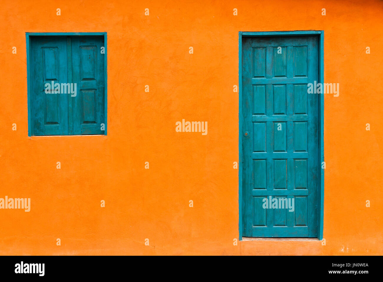Colorful Orange Colonial Facade with Blue Greenish Door and Windows Stock Photo