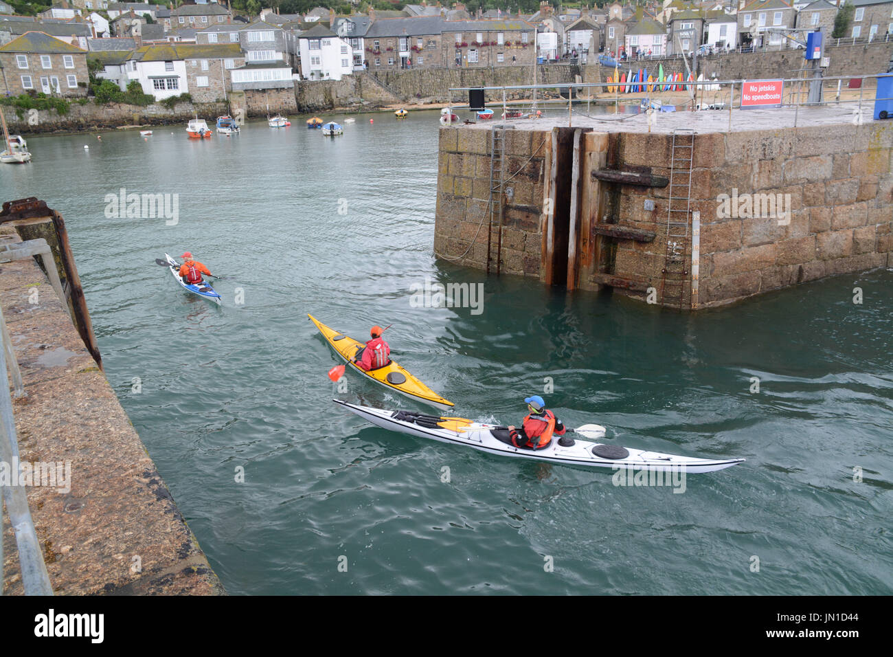 Mousehole, Cornwall, UK. 29th July, 2017. UK Weather. People were still out enjoying themselves at Mousehole, despite the rain and clouds. Credit: cwallpix/Alamy Live News Stock Photo