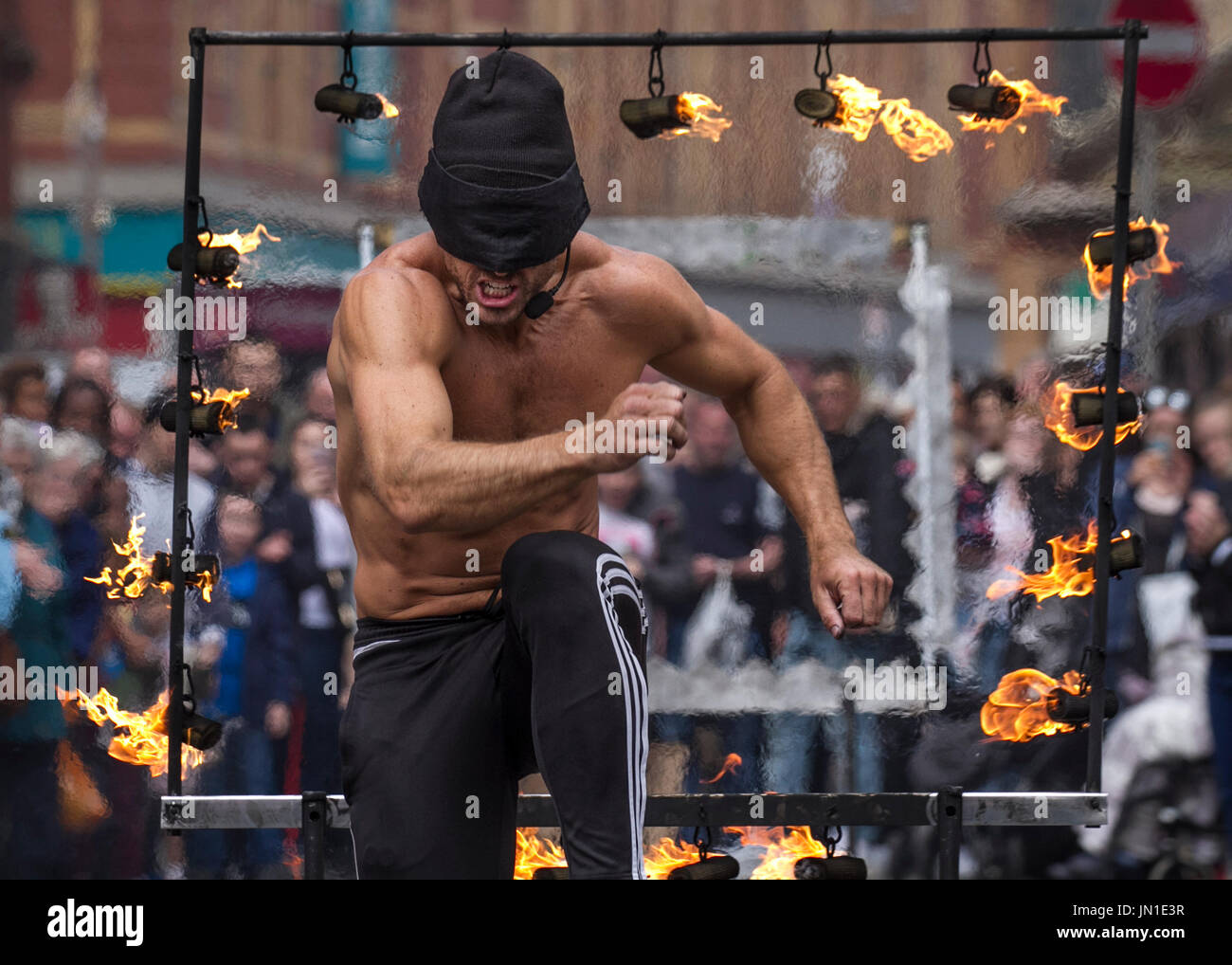Blackpool, Lancashire, UK. UK Weather. 29th July, 2017. Liam an 'Olympic athlete known as The Stunt Runner', performs a blindfolded, death defying stunt for crowds in the resort. JUMPING over hurdles made of chainsaws and fire while blindfolded helped a Tynedale Harrier to the world title. Liam Collins, street entertainer, continues to raise funds for World Masters Athletics Indoor Championships, as a death-defying street performer up-and-down the country. MediaWorldImages/AlamyLiveNews Stock Photo