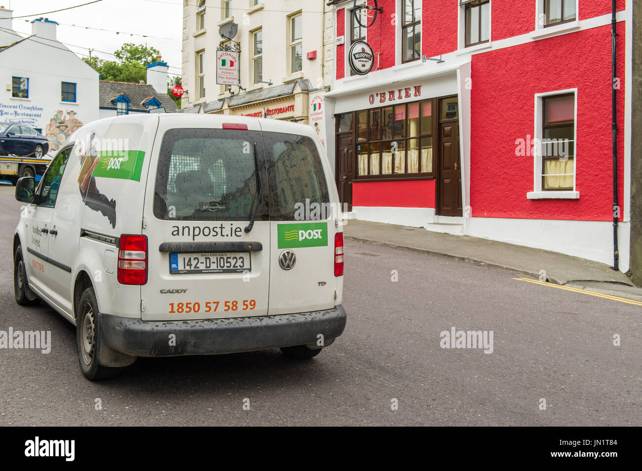 Irish Post Office (An Post) van drives up Ballydehob Main Street, Ballydehob, West Cork, Ireland. Stock Photo