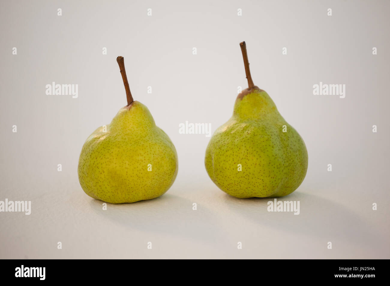 Close-up of two pears against white background Stock Photo - Alamy