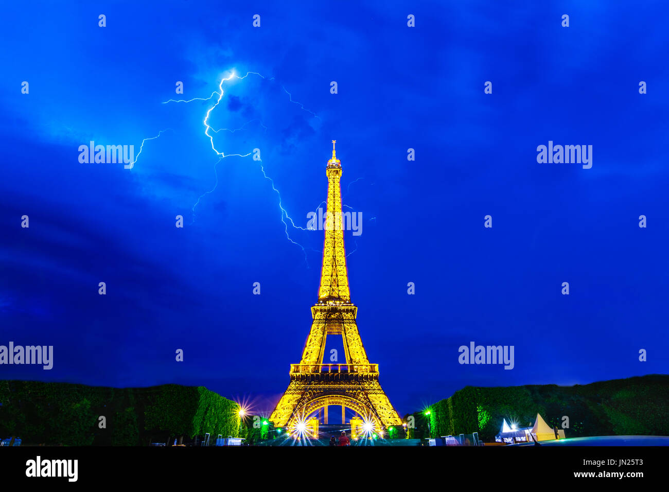 Paris, France - June 8th, 2014: Thunderstorms behind Eiffel Tower illuminated at night-during Roland Garros tour. The Eiffel Tower was built in 1889,  Stock Photo