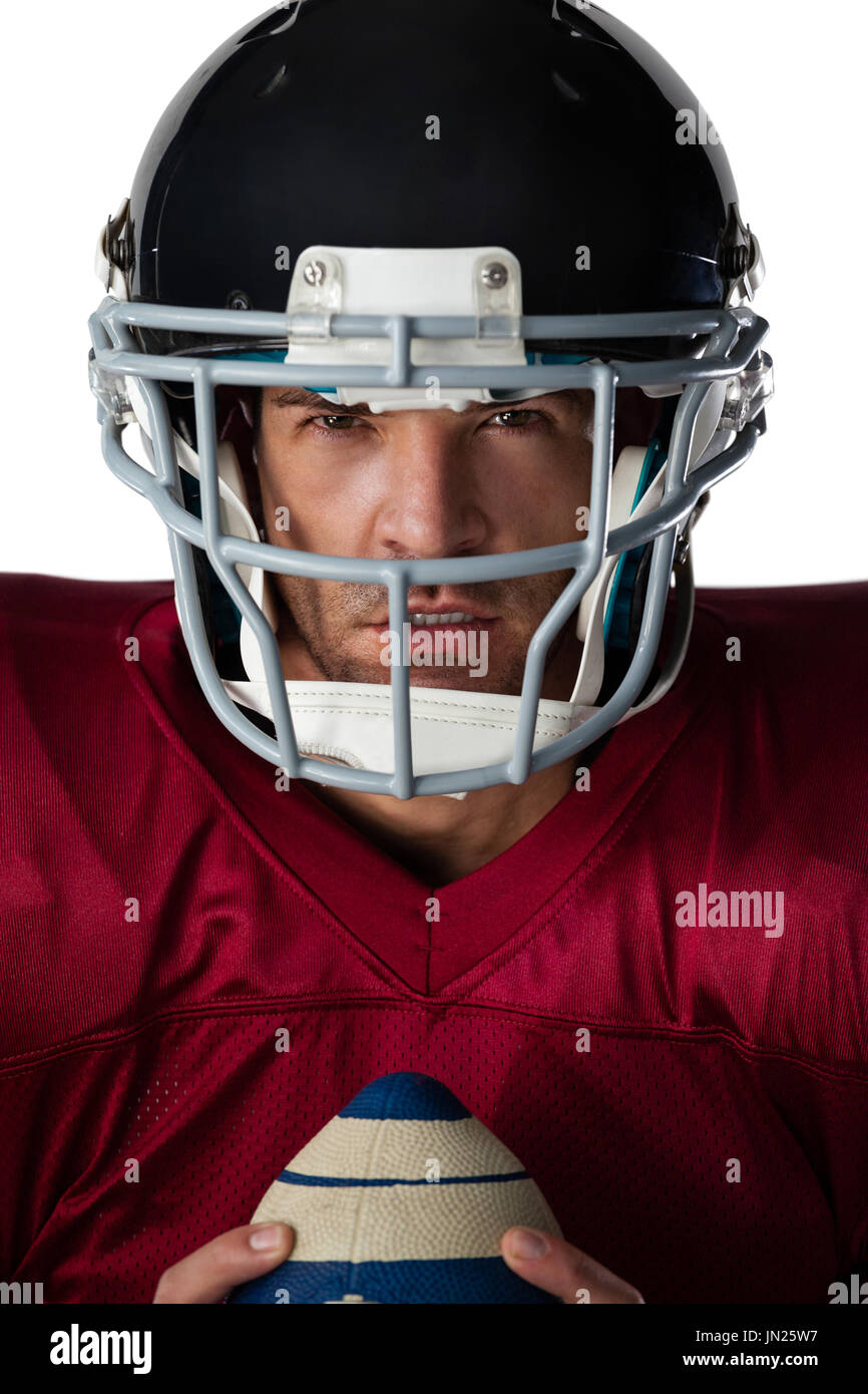 Portrait of determined American football player wearing helmet holding