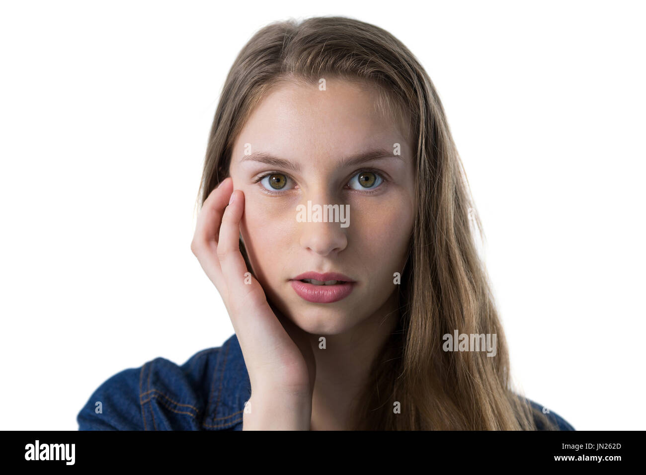 Portrait of confused teenage girl with hand on face Stock Photo