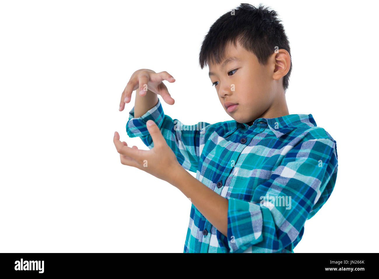 Boy pretending to hold invisible object against white background Stock ...