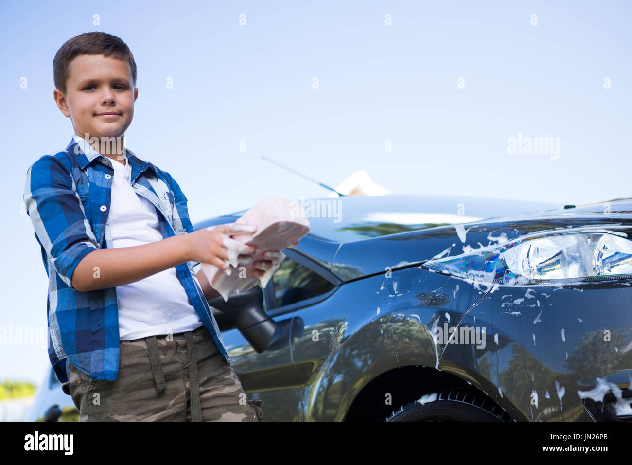 Portrait of teenage boy washing a car on a sunny day Stock Photo Alamy